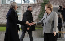 German Chancellor Angela Merkel, right, welcomes British Prime Minister Theresa May prior to a meeting in the chancellery in Berlin, Germany, Tuesday, Dec. 11, 2018. May is visiting several European countries to seek "assurances" on the Brexit agreement with the European Union to aid its passage through Britain's parliament. (AP Photo/Michael Sohn)