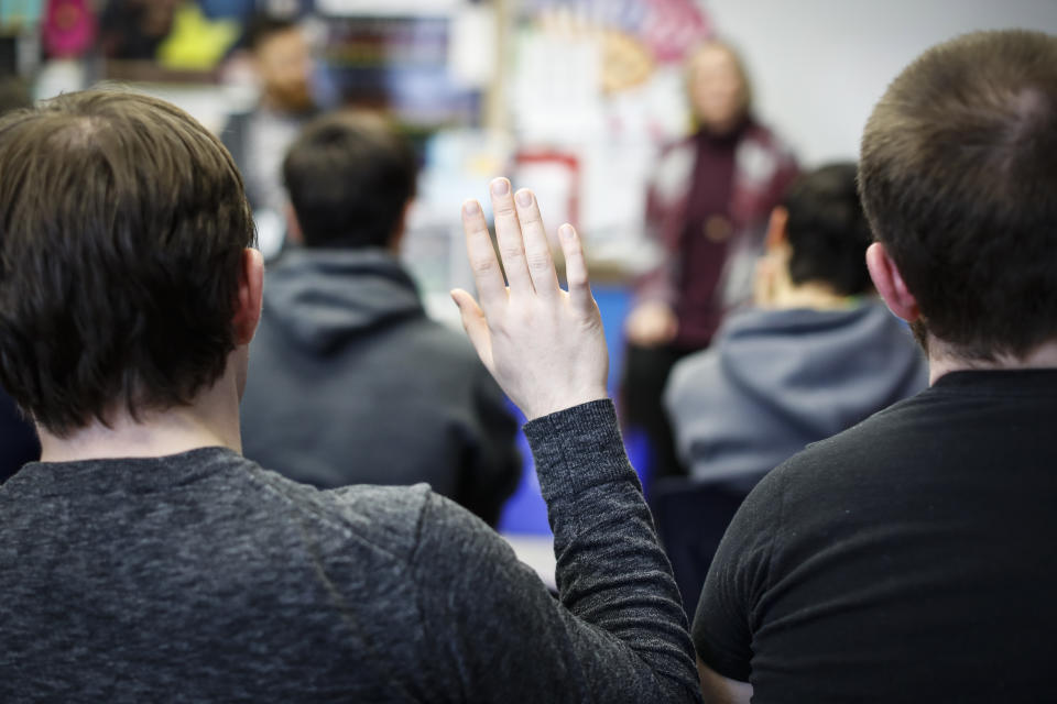 In this Thursday, Jan. 24, 2019, photo students ask questions as social studies teachers Judi Galasso and Jonathan Duffy lead the introductory class of their American Thought and Political Radicalism course at Thomas Worthington High School, in Worthington, Ohio. (AP Photo/John Minchillo)