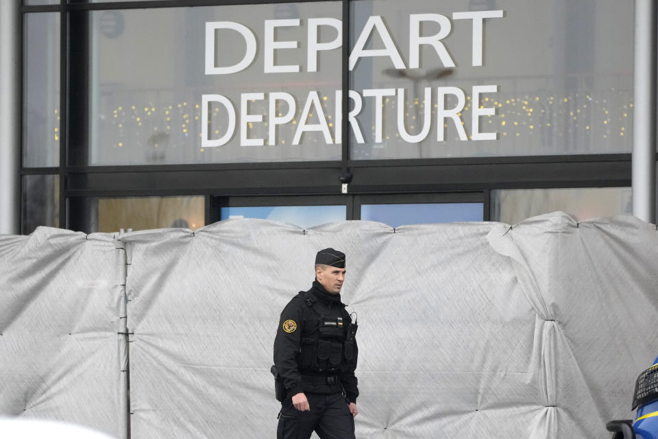 A police officer patrols at the Vatry airport, eastern France, Saturday, Dec. 23, 2023 in Vatry, eastern France. About 300 Indian citizens heading to Central America were sequestered in a French airport for a third day Saturday because of an investigation into suspected human trafficking, authorities said. The 15 crew members of the Legend Airlines charter flight en route from United Arab Emirates to Nicaragua were questioned and released, according to a lawyer for the small Romania-based airline. (AP Photo/Christophe Ena)