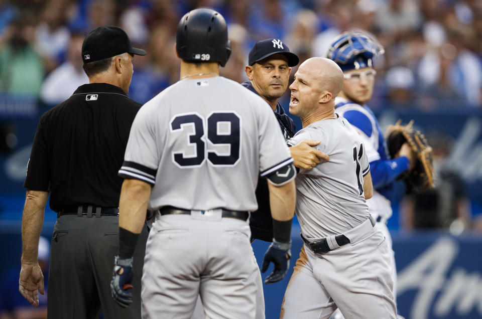 TORONTO, ONTARIO - AUGUST 9: Brett Gardner #11 of the New York Yankees is held back by manager Aaron Boone as he argues with umpires while playing the Toronto Blue Jays  in the fourth inning during their MLB game at the Rogers Centre on August 9, 2019 in Toronto, Canada. (Photo by Mark Blinch/Getty Images)