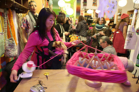 A woman spools yarn as she takes part in the Pussyhat social media campaign to provide pink hats for protesters in the women's march in Washington, D.C., the day after the presidential inauguration, in Los Angeles, California, U.S., January 13, 2017. REUTERS/Lucy Nicholson