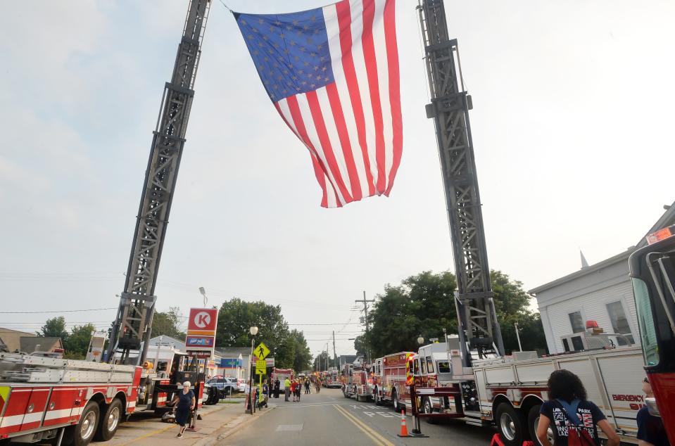 Firefighters pay respects as the body of Fuller Hose Co. volunteer Shawn Giles, 53, is taken to a funeral home in North East on Aug. 21, the day after he was struck by a car while directing traffic at an accident scene in North East Township.