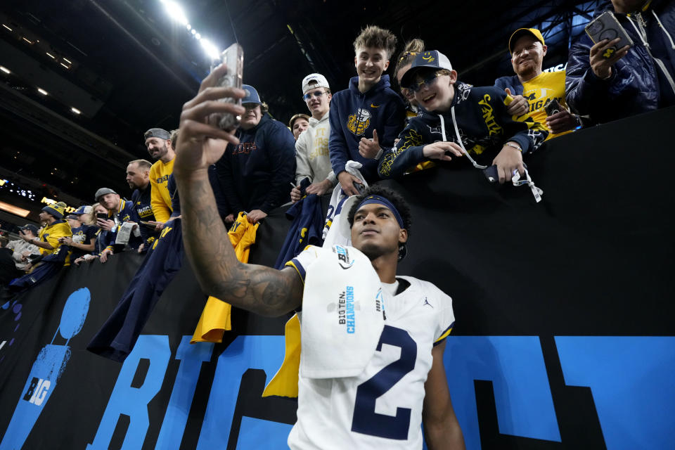 Michigan defensive back Will Johnson (2) celebrates with fans after the Big Ten championship NCAA college football game against Iowa, Saturday, Dec. 2, 2023, in Indianapolis. Michigan won 26-0. (AP Photo/AJ Mast)