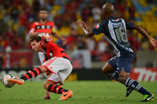 El centrocampista brasileño del Flamengo Elano (i) trata de driblar a un jugador del ecuatoriano Emelec durante un encuentro de Copa Libertadores, en Río de Janeiro el 26 de febrero de 2014 (AFP/Archivos | Christophe Simon)