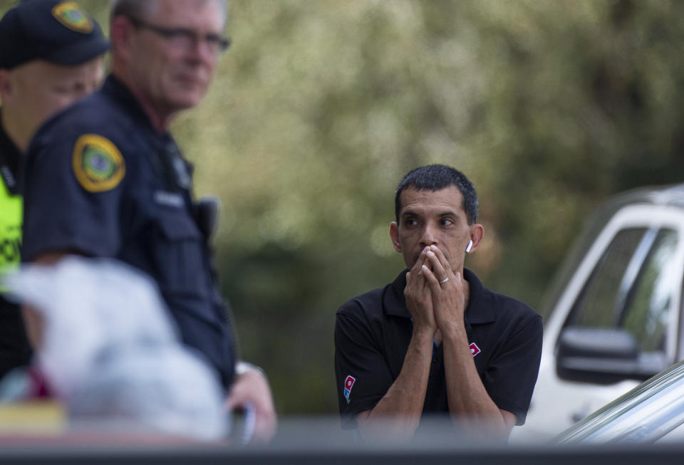 A man watches as the Houston Police officers investigate the scene of a fatal shooting at the Dunkin' Donuts on the 5800 block of Memorial Drive Friday, Feb. 15, 2019, in Houston. (Godofredo A. Vasquez/Houston Chronicle via AP)