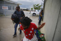 Haitians deported from the United States leave Toussaint Louverture International Airport under a rain shower in Port au Prince, Haiti, Sunday, Sep. 19, 2021. Thousands of Haitian migrants have been arriving to Del Rio, Texas, to ask for asylum in the U.S., as authorities begin to deported them to back to Haiti. (AP Photo/Joseph Odelyn)