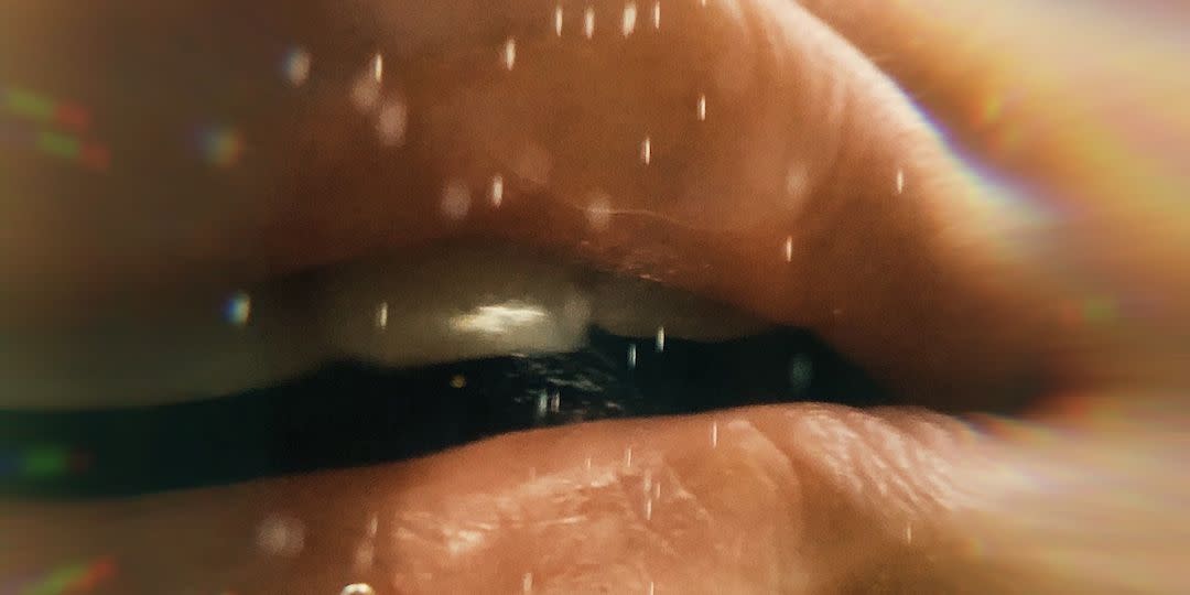 closeup of a woman's lips pressed against glass