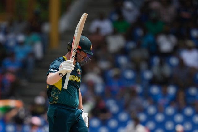 Australia’s Travis Head raises his bat to celebrate his half-century