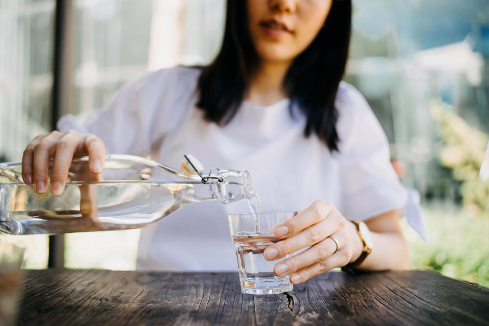 A woman pouring water into her glass