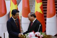 Vietnamese Prime Minister Nguyen Xuan Phuc, right, and Japanese Prime Minister Shinzo Abe shake hands at the end of a joint press briefing following their meeting at Phuc's Cabinet Office in Hanoi, Vietnam, Monday, Jan. 16, 2017. Abe is on a two-day official visit to Vietnam. (Hoang Dinh Nam/Pool Photo via AP)