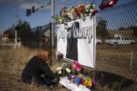 Melody Siewell leaves flowers at a memorial outside Umpqua Community College in Roseburg, Oregon, United States, October 3, 2015. REUTERS/Lucy Nicholson