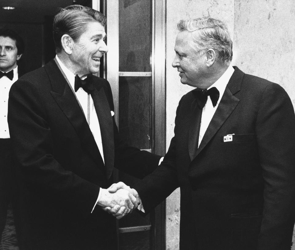 FILE - In this Jan. 26, 1985 file photo, President Ronald Reagan, left, shakes hands with Barron Hilton upon his arrival at the Capitol Hill in Washington to attend the annual Alfalfa Club meeting. Hilton, a hotel magnate who expanded his father's chain and became a founding owner in the American Football League, has died. Hilton's family says he died Thursday, Sept. 19, 2019, of natural causes at age 91 in his Long Angeles home. He transformed Hilton into the industry's top brand during his 30 years as its chief executive. (AP Photo/Budd Gray, File)