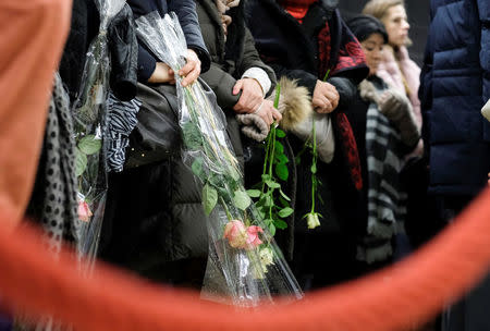 People hold flowers as they attend a ceremony at the Maelbeek metro station to commemorate two years since bombings at Brussels airport and a metro station, in Brussels, Belgium March 22, 2018. Olivier Hoslet/Pool via REUTERS