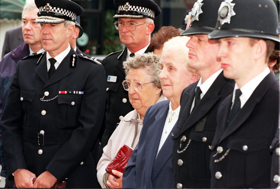 Metropolitan Police Commissioner Sir Paul Condon (left) stands with Liz Blakelock (glasses), the mother of murdered policeman Keith Blakelock, as they witness a wreath being layed at his memorial in Muswell Hill in London, on the 10th anniversary of the Bridgewater Farm riots, in which Pc Blakelock was killed.  Standing beside Mrs Blakelock is Peggy Spinlaw, who tends the memorial regularly.   (Photo by Louisa Buller - PA Images/PA Images via Getty Images)