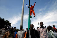 <p>A supporter of Kenyan opposition leader Raila Odinga of the National Super Alliance (NASA) coalition stands on a pole as he blows a horn ahead of his planned swearing-in ceremony as the President of the People’s Assembly in Nairobi, Kenya, Jan. 30, 2018. (Photo: Baz Ratner/Reuters) </p>