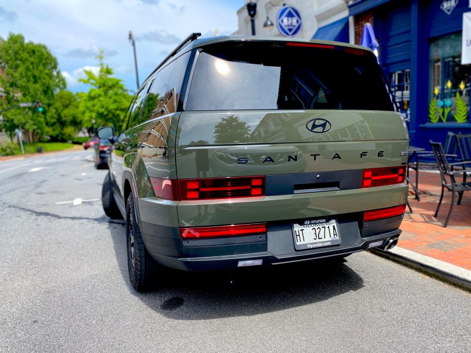 The rear end of a green 2024 Hyundai Santa Fe XRT SUV.