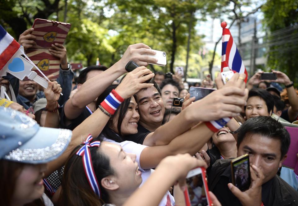 Former Thai Prime Minister Abhisit Vejjajiva is mobbed by supporters during anti-government demonstrations in central Bangkok