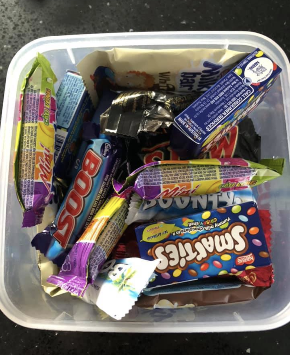 Photo shows a plastic container filled with chocolates. 