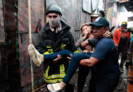 <p>Firefighters help evacuate a woman affected by smoke from a fire at the Oriental Market in Managua, Nicaragua, May 14, 2017. (Photo: Oswaldo Rivas/Reuters) </p>