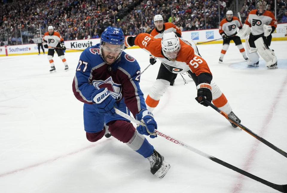 Colorado Avalanche left wing Jonathan Drouin, left, collects the puck with Philadelphia Flyers defenseman Rasmus Ristolainen in pursuit during the third period of an NHL hockey game Saturday, Dec. 9, 2023, in Denver. (AP Photo/David Zalubowski)