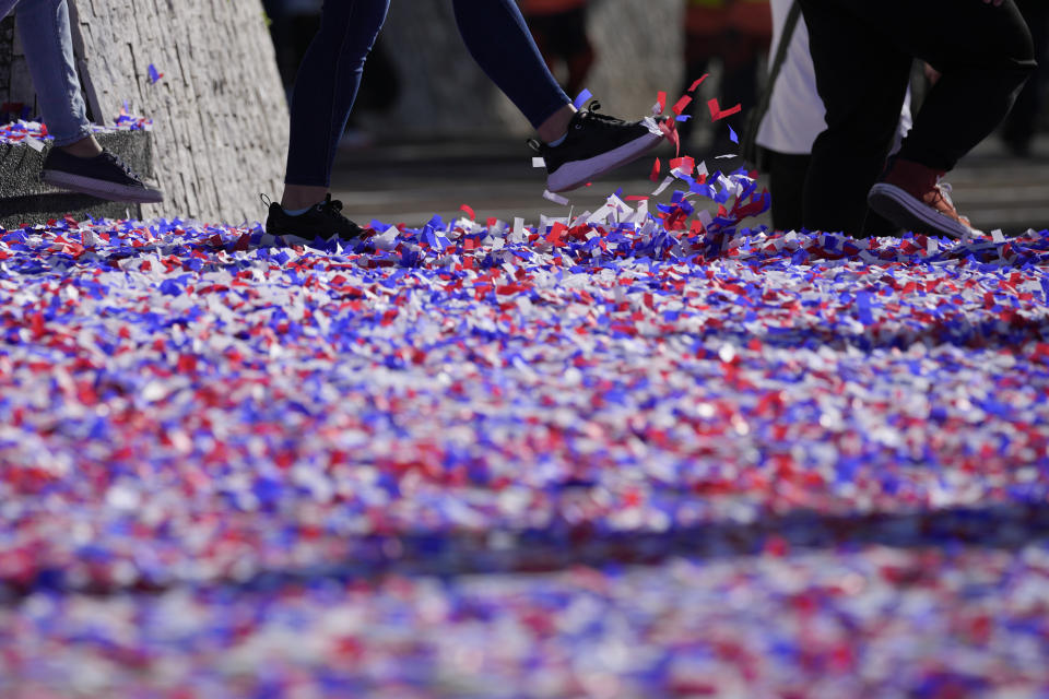 A woman kicks confetti after ceremonies marking the 37th anniversary of the near-bloodless coup popularly known as "People Power" revolution that ousted the late Philippine dictator Ferdinand Marcos from 20-year-rule at the People's Power Monument in Quezon city, Philippines on Saturday Feb. 25, 2023. It is the first year marking the event under the rule of Marcos Jr. (AP Photo/Aaron Favila)