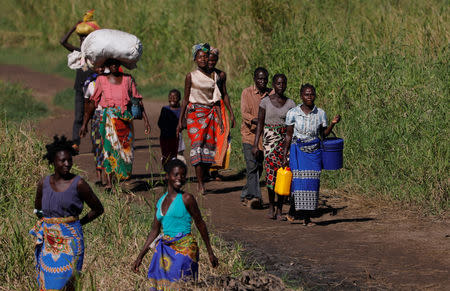 Maria Jofresse, 25, walks with her parents to a camp for the displaced in the aftermath of Cyclone Idai, in John Segredo, near Beira, Mozambique April 3, 2019. REUTERS/Zohra Bensemra/Files