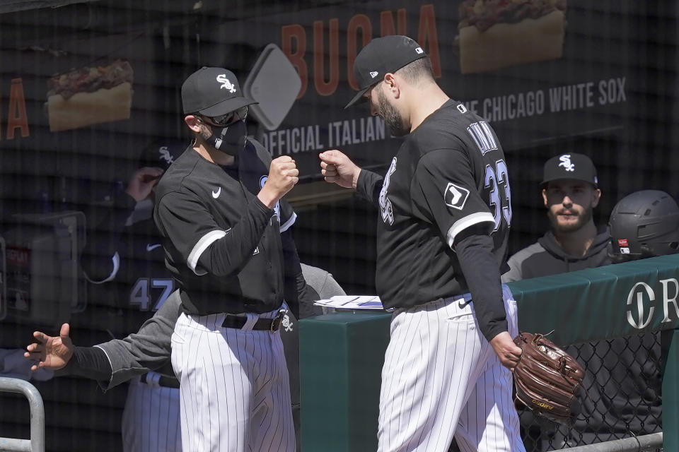 Chicago White Sox pitching coach Ethan Katz, left, greets starting pitcher Lance Lynn outside the dugout after Lynn retired the Minnesota Twins in the fifth inning of a baseball game Thursday, May 13, 2021, in Chicago. (AP Photo/Charles Rex Arbogast)