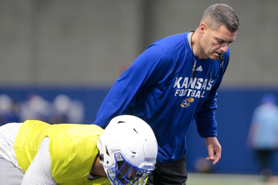 Kansas defensive tackles coach Jim Panagos works his players through drills during a spring ball practice this year at the team's indoor facility.