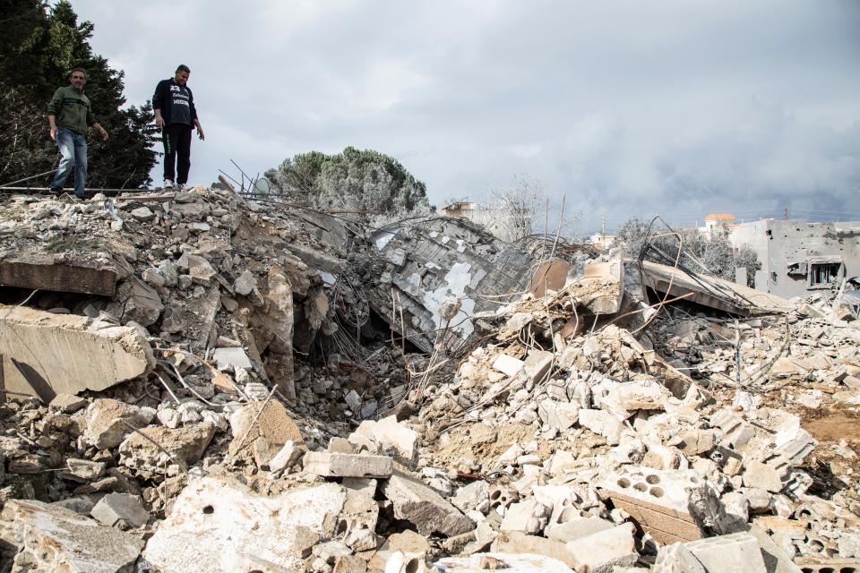 Men check the destruction following an Israeli airstrike the previous day on the village of Taybeh near the border with Israel in southern Lebanon, on 15 February 2024 (AFP via Getty Images)