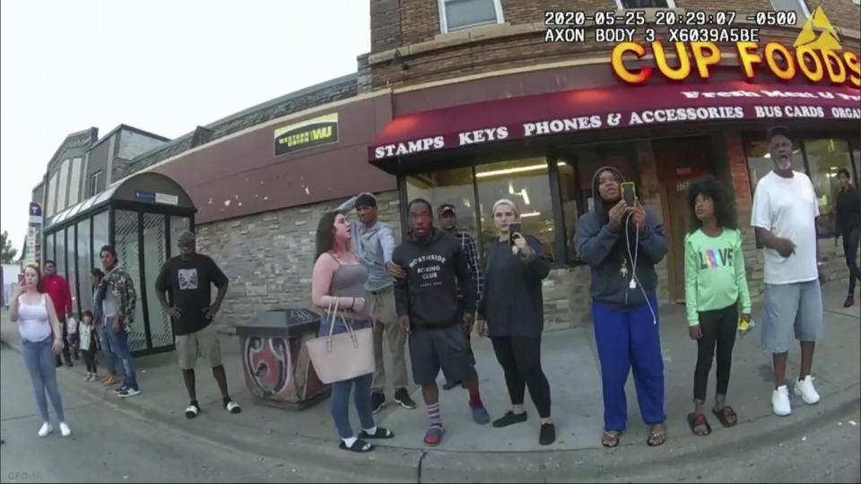 FILE - In this image from a police body camera, bystanders including Alyssa Funari, left filming, Charles McMillan, center left in light colored shorts, Christopher Martin center in gray, Donald Williams, center in black, Genevieve Hansen, fourth from right filming, Darnella Frazier, third from right filming, witness as then Minneapolis police officer Derek Chauvin pressed his knee on George Floyd's neck for several minutes, killing Floyd on May 25, 2020 in Minneapolis. (Minneapolis Police Department via AP, File)