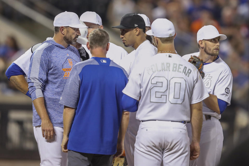 New York Mets relief pitcher Edwin Diaz, center, talks to manager Mickey Callaway, left, before leaving the baseball game during the ninth inning against the Atlanta Braves, Saturday, Aug. 24, 2019, in New York. (AP Photo/Mary Altaffer)