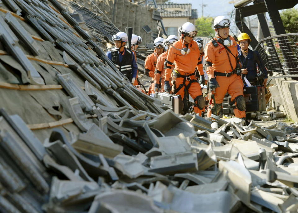 Firefighters walk through damage