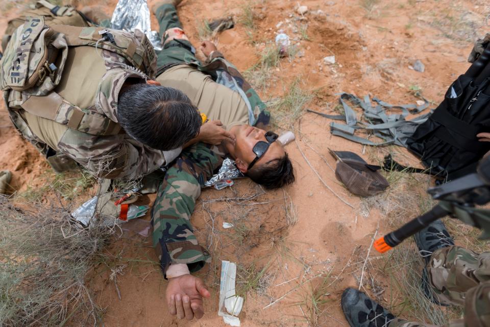 A U.S. Border Patrol Search Trauma and Rescue (BORSTAR) candidate checks a migrant's pulse during their last field rescue training course on Thursday, Aug. 18, 2022, at McGregor Training Area, Range 11 in Ft. Bliss, before graduating the following day.