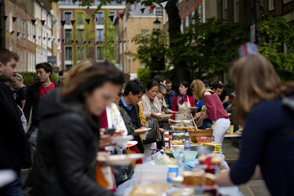 People share food during the Big Lunch celebrations on Holland Street in London, Sunday, May 7, 2023. The Big Lunch is part of the weekend of celebrations for the Coronation of King Charles III. (AP Photo/Andreea Alexandru)