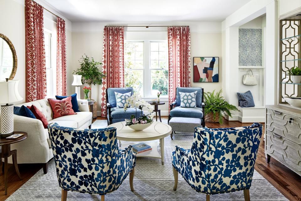neutral-colored living room with blue chairs and red accent pieces