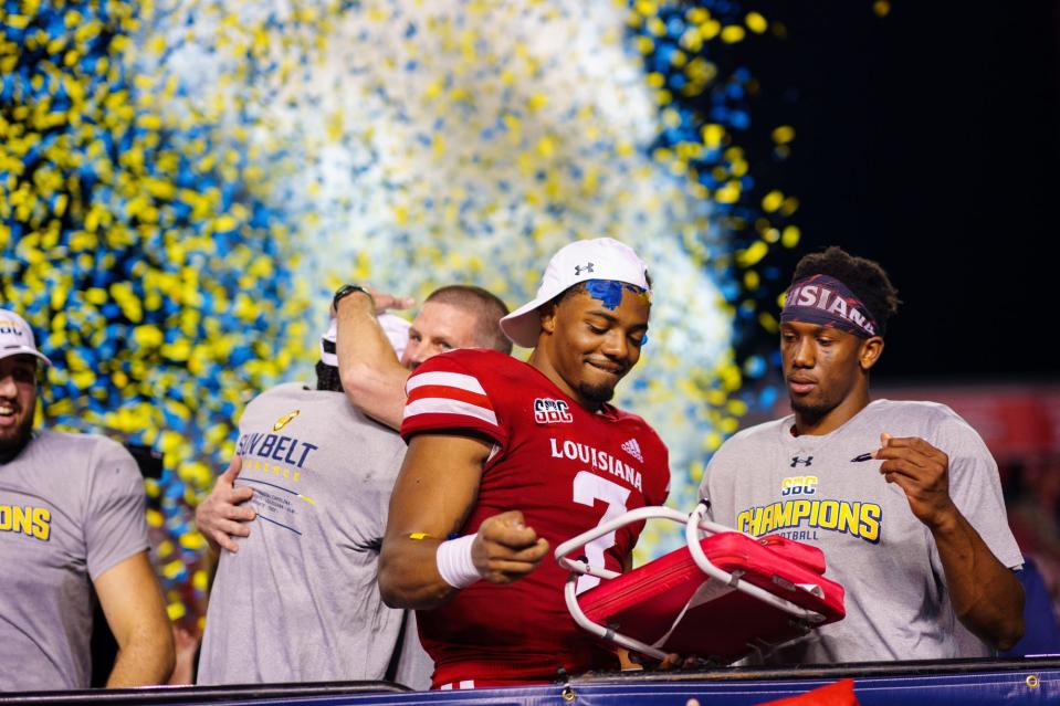 Dec 4, 2021; Lafayette, LA, USA; Louisiana Ragin' Cajuns Linebacker Ferrod Gardner (7) and quarterback Levi Lewis (right) celebrates after a 24-16 victory over the Appalachian State Mountaineers in the Sun Belt Conference championship game. Mandatory Credit: Andrew Wevers-USA TODAY Sports