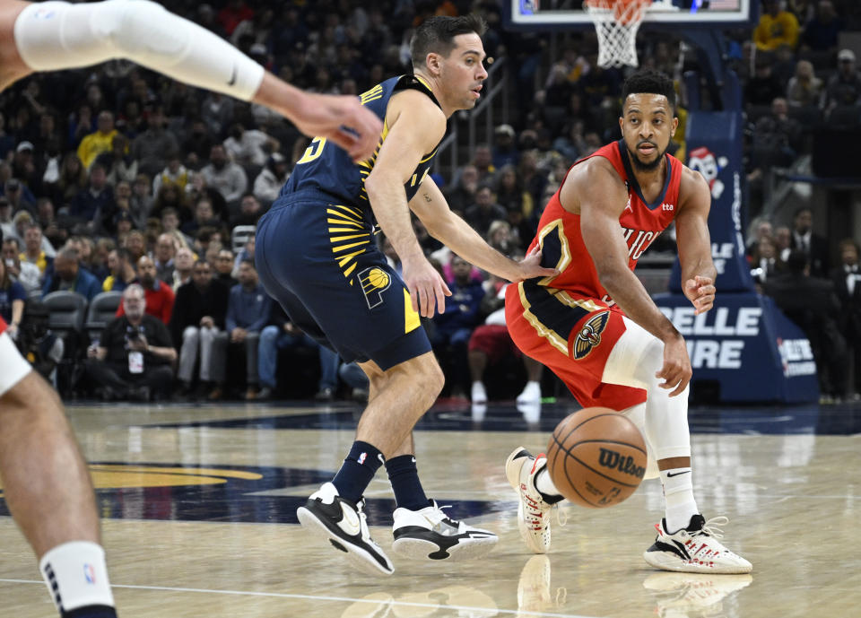 New Orleans Pelicans guard CJ McCollum (3) passes the ball around Indiana Pacers guard T.J. McConnell (9) during the first quarter of an NBA Basketball game, Monday, Nov. 7, 2022, in Indianapolis, Ind. (AP Photo/Marc Lebryk)