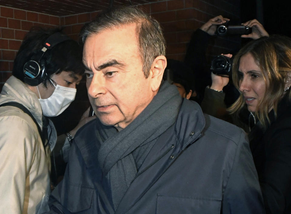 FILE - In this April 3, 2019, file photo, former Nissan Chairman Carlos Ghosn, center, returns to his residence in Tokyo. Japanese court approves release for detained Nissan ex-chair Ghosn on 500 million yen, or $4.5 million, bail.(Kyodo News via AP)