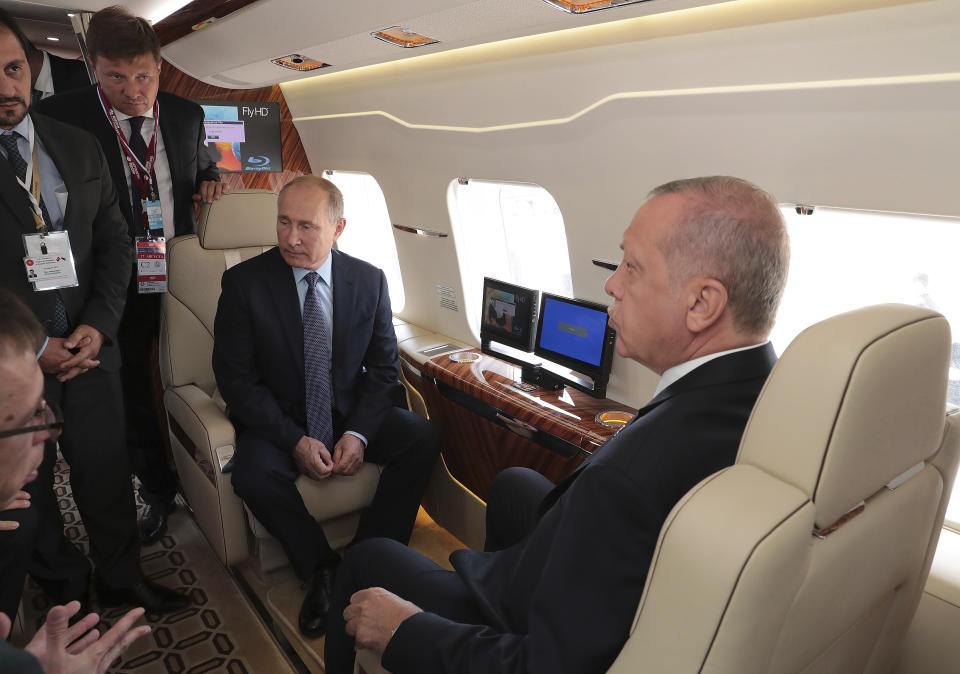 Russia's President Vladimir Putin, seated left and Turkey's President Recep Tayyip Erdogan, right, inspect an aircraft during the MAKS-2019 International Aviation and Space Show in Zhukovsky, outside Moscow, Russia, Tuesday, Aug. 27, 2019. Erdogan is on a short working visit in Russia.(Presidential Press Service via AP, Pool)