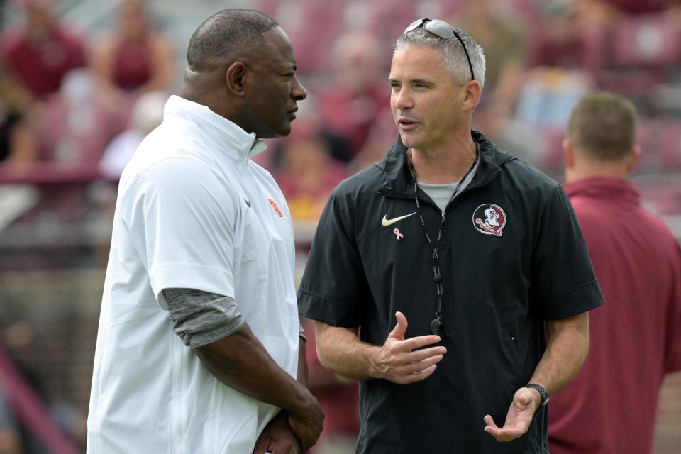 Syracuse head coach Dino Babers, left, and Florida State head coach Mike Norvell chat on the field before an NCAA college football game, Saturday, Oct. 14, 2023, in Tallahassee, Fla.