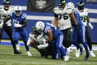 New York Jets' Josh Johnson is sacked by Indianapolis Colts' Antwaun Woods (96) during the first half of an NFL football game, Thursday, Nov. 4, 2021, in Indianapolis. (AP Photo/Michael Conroy)