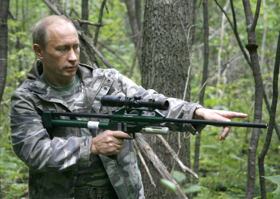 In this Sunday, Aug. 31, 2008 file pool photo then Prime Minister Vladimir Putin holds a tranquilizer gun in a Russian Academy of Sciences reserve in Russia's Far East. Putin has become alternately notorious and beloved for an array of adventurous stunts, including posing with a tiger cub and riding a horse bare-chested. (AP Photo/RIA Novosti, Alexei Druzhinin, POOL, file)