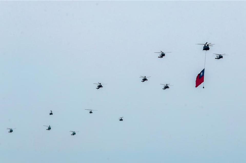 CH-47SD，契努克直升機吊掛著國旗，後面兩架UH-60M，黑鷹直升機伴飛，緊追著是三架AH-64E阿帕契攻擊直升機，接著是三架AH-1W超級眼鏡蛇攻擊直升機，最後是三架S-70C反潛直升機。（陳麒全攝）
