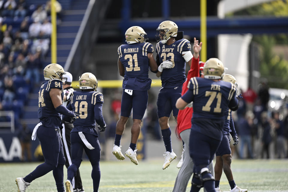 Navy safety Xavier McDonald (31) and linebacker Jordan Sanders (33) celebrate a missed field goal by Air Force place kicker Matthew Dapore during the first half of an NCAA college football game, Saturday, Oct. 21, 2023, in Annapolis, Md. (AP Photo/Terrance Williams)