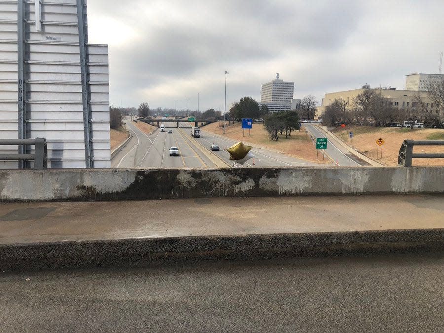 The south side of S.E. 6th Avenue's bridge over Interstate 70 remained without some of its railing Monday after a car smashed through that railing Sunday.