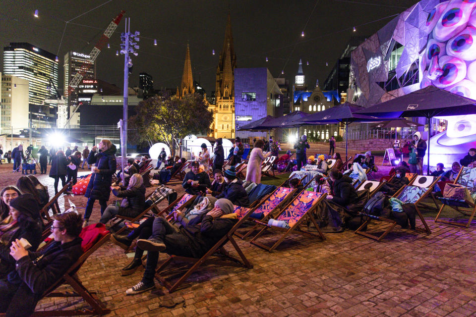 Fans watch a screening of the final episode of Australian TV soap, Neighbours, at Federation Square in Melbourne, Australia, Thursday, July 28, 2022. After 37 years the final episode of Australia's longest-running TV show was broadcast in Australia. (Diego Fedele/AAP via AP)