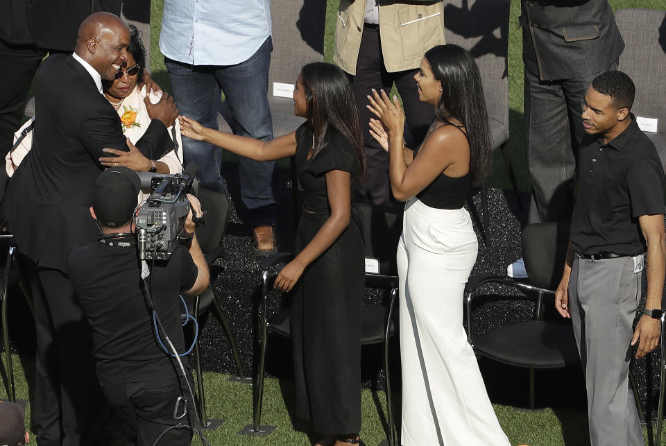 Former San Francisco Giants player Barry Bonds, left, hugs his mother, Pat, as his children Aisha, Shikari, middle, and Nikolai watch as Bonds is honored during a ceremony to retire his jersey number before a baseball game between the Giants and the Pittsburgh Pirates in San Francisco, Saturday, Aug. 11, 2018. (AP Photo/Jeff Chiu, Pool)