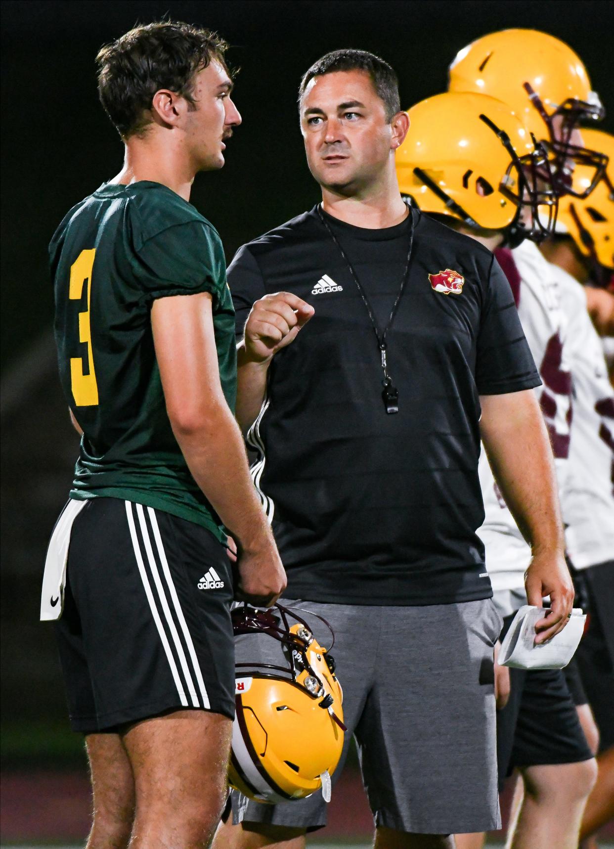 Bloomington North’s Dash King talks with quarterbacks coach Anthony Lindsey during the first day of football practice at North on Monday, July 31, 2023.