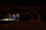 Migrants mainly from Honduras and Nicaragua sit in line after turning themselves in upon crossing the U.S.-Mexico border Monday, May 17, 2021, in La Joya, Texas. The Biden administration has agreed to let up to about 250 people a day in the United States at border crossings with Mexico to seek refuge, part of negotiations to settle a lawsuit over pandemic-related powers that deny migrants a right to apply for asylum, an attorney said Monday. (AP Photo/Gregory Bull)