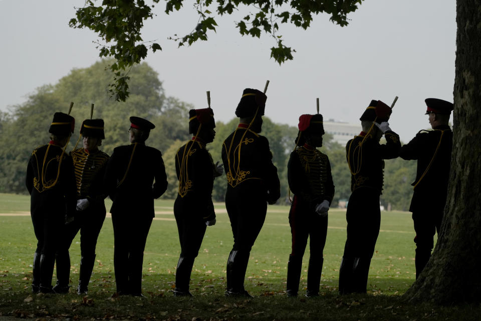 Troopers of The King's Troop Royal Horse Artillery take shade under a tree before they fire a 41 Gun Royal Salute supported by the Band of the Grenadier Guards, on the first anniversary of the death of Queen Elizabeth II, in Hyde Park in London, Friday, Sept. 8, 2023. (AP Photo/Kirsty Wigglesworth)